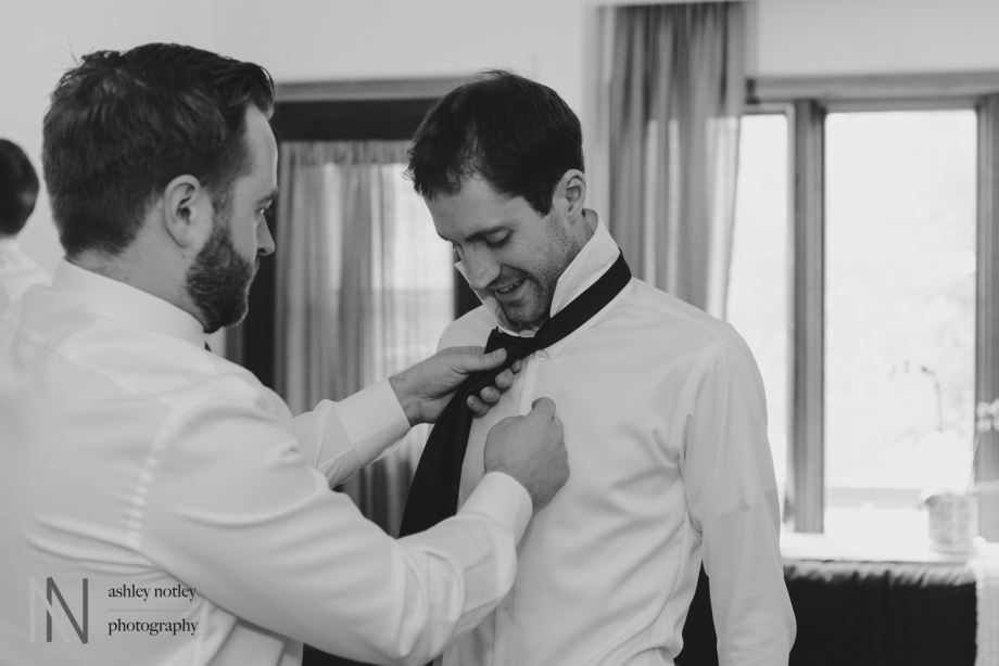 Groom and groomsmen putting on their ties