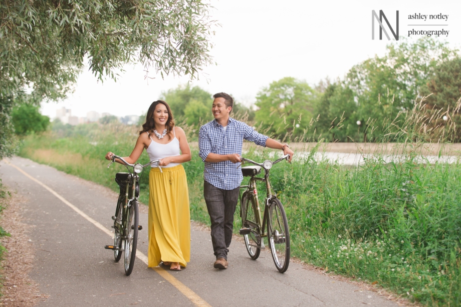Couple walking with vintage Raleigh bikes at engagement photo session