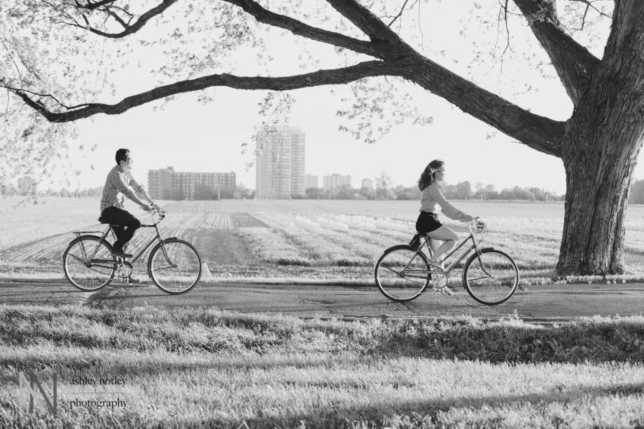 Couple biking at the experimental farm during engagement photo session
