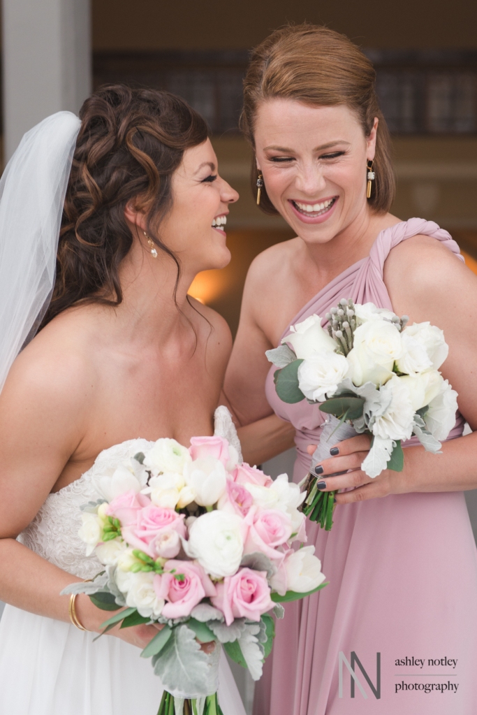 Bride and maid of honor laughing together at the Canadian Museum of Nature