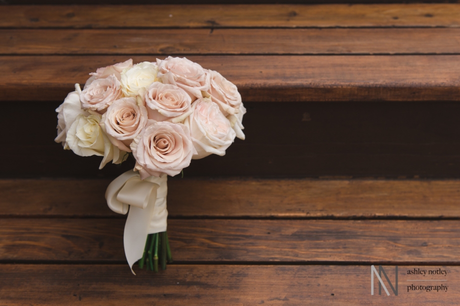 Bride's blush bouquet of roses on wooden steps