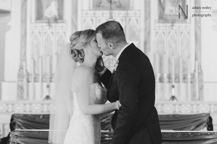 Bride and groom first kiss at Our lady of visitation church