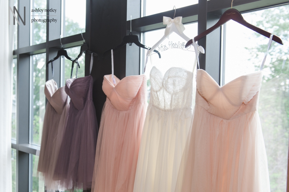 Sarah Seven bridal gown with bridesmaids pastel dresses hanging in the window