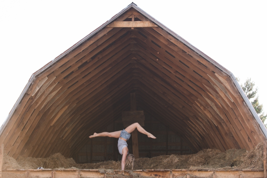 Handstand in barn attic with hay